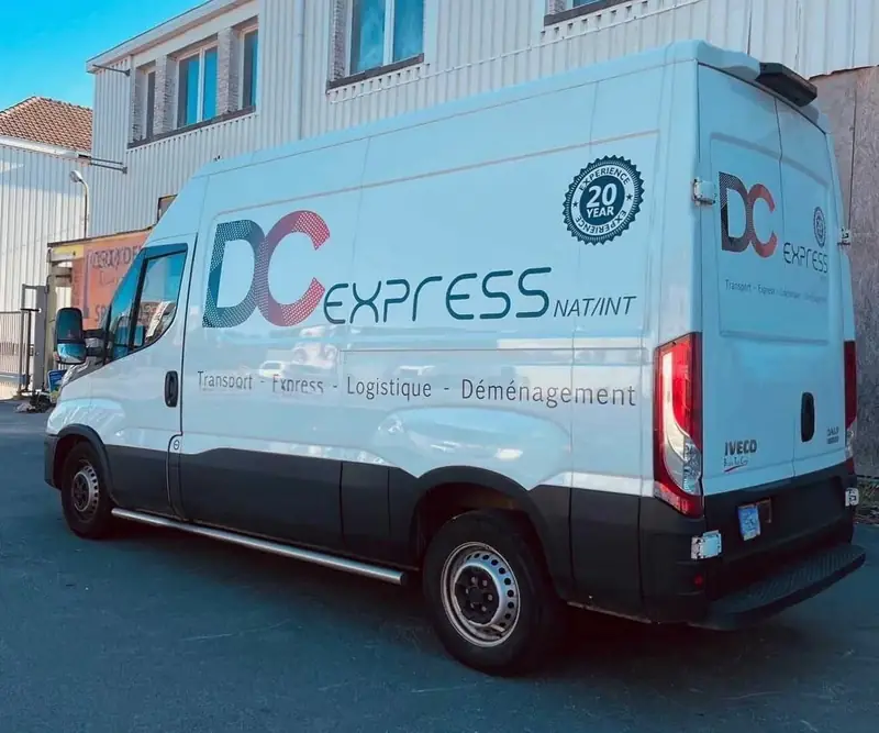 Camionnette blanche DC Express garée devant un bâtiment